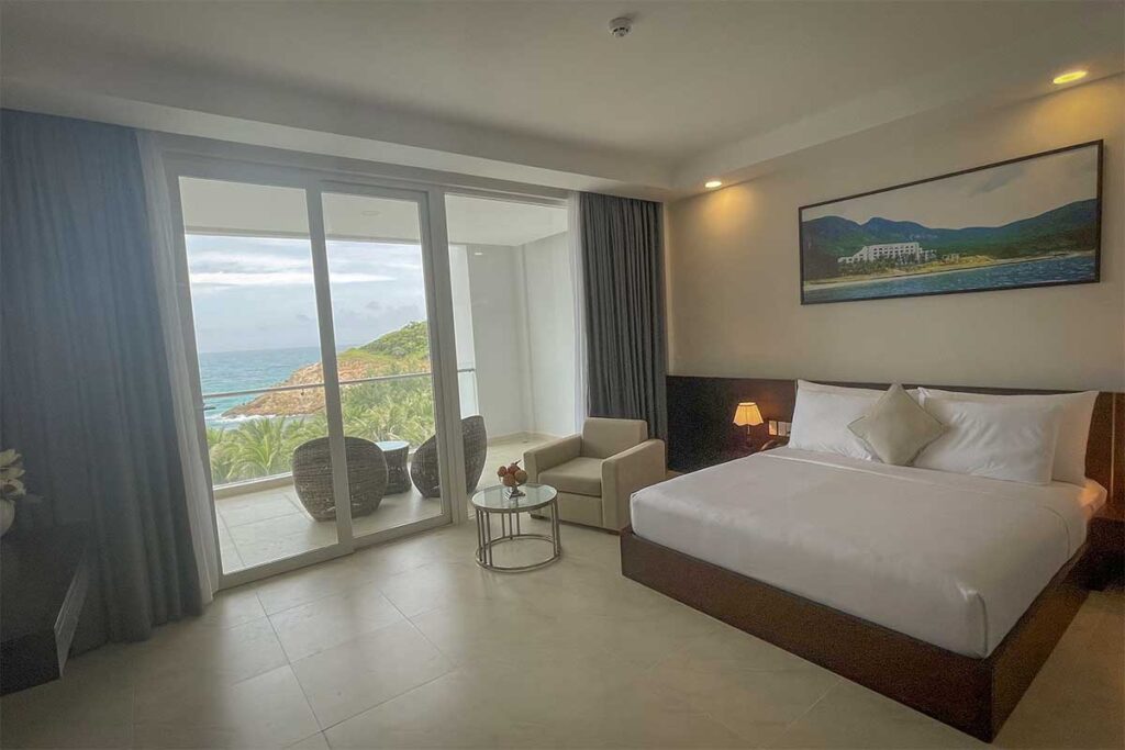 Spacious room with balcony and ocean view at Orson Hotel & Resort Con Dao overlooking the coastline and tropical landscape