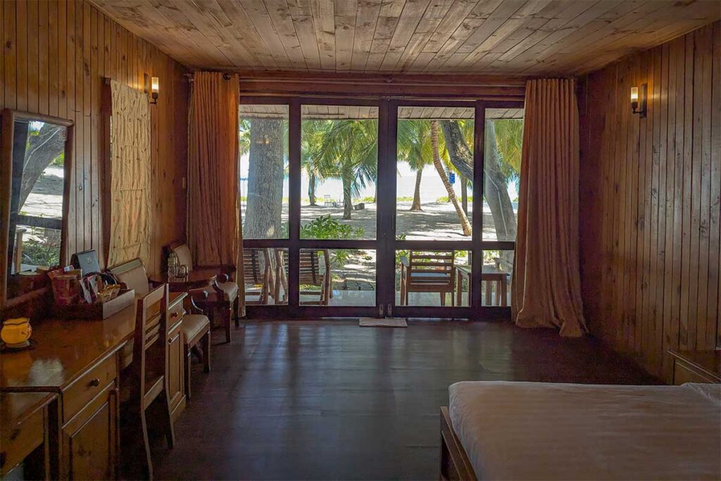 Wooden bungalow interior at Tan Son Nhat Con Dao Resort with large windows and view toward the beach