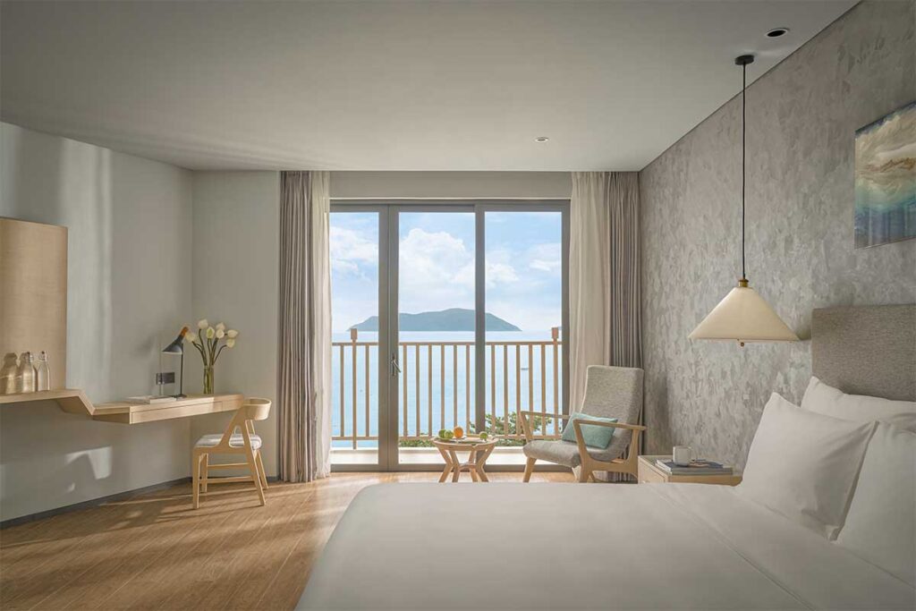 Modern hotel room at The Secret Con Dao with balcony overlooking the ocean and minimalist interior design