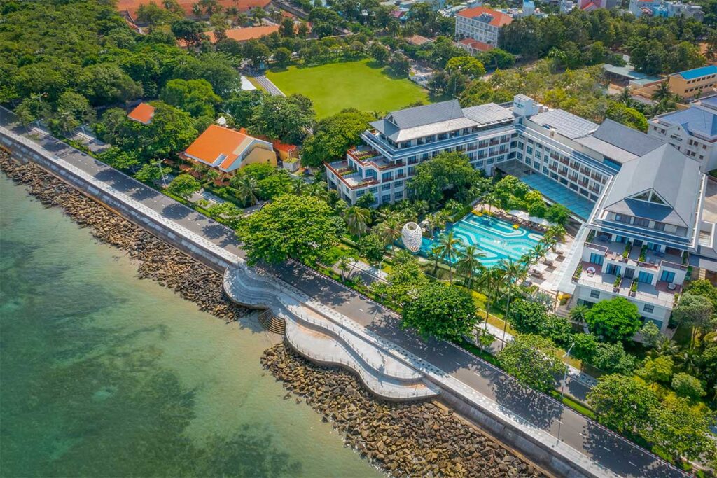 Aerial view of The Secret Con Dao hotel located along the coastal road with swimming pool and oceanfront setting