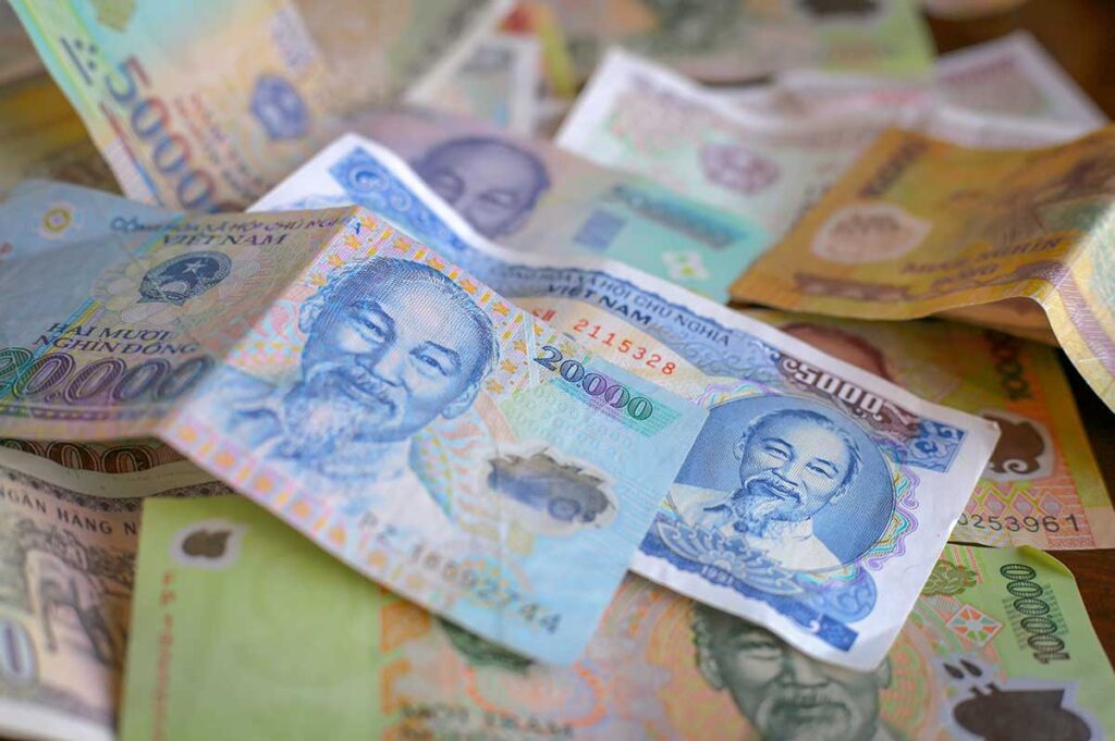 Close-up of Vietnamese dong banknotes in different colors, showing how similar designs can cause confusion when handling money in Vietnam