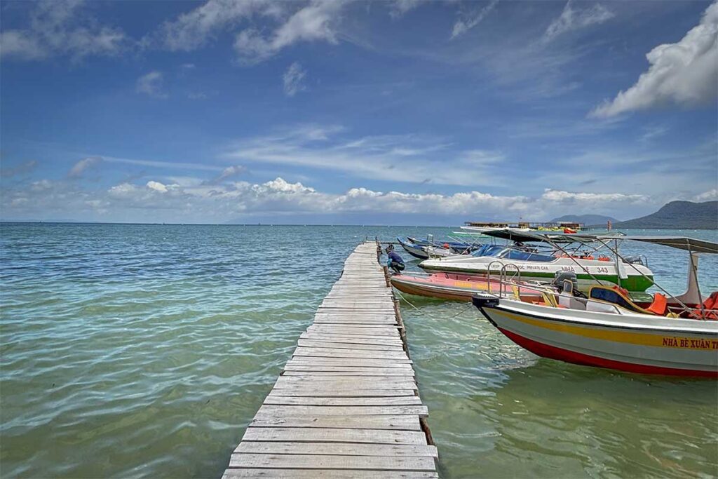 Wooden pier with boats for transfer to Starfish Beach Phu Quoc Rach Vem