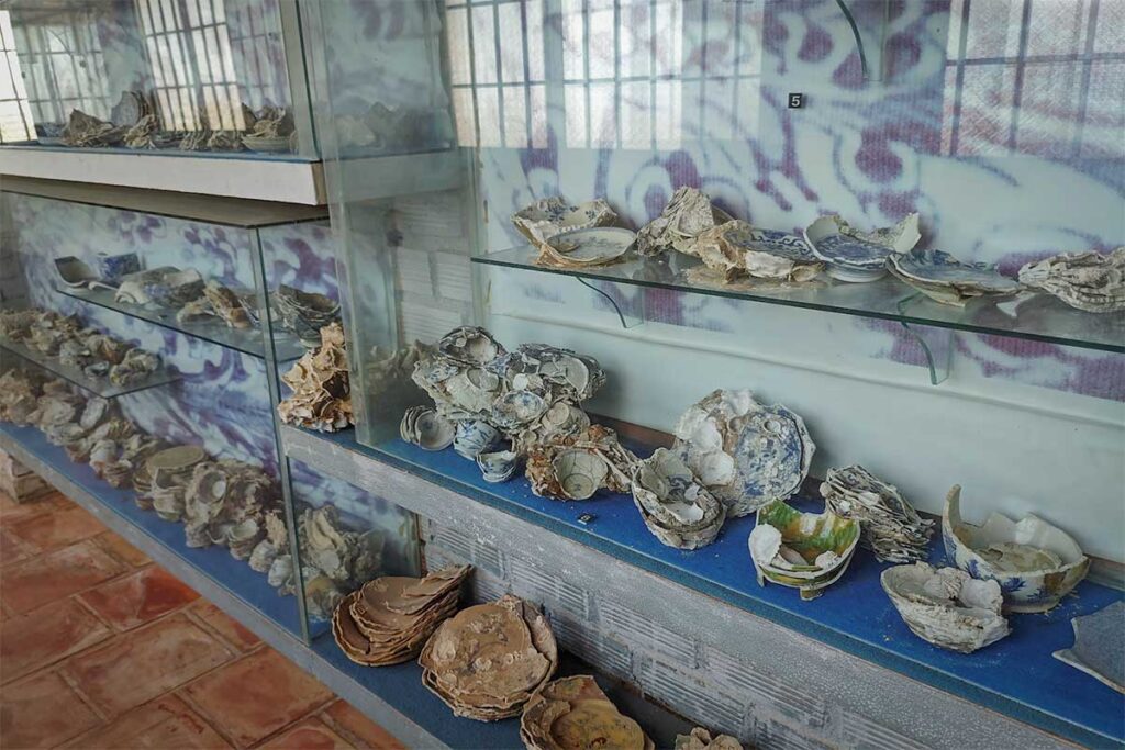 Broken ceramic bowls and pottery displayed inside Coi Nguon Museum Phu Quoc showing old shipwreck artifacts and historical collections