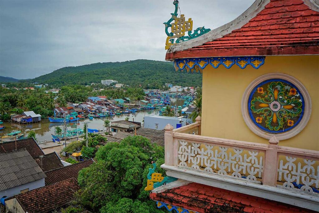 Rooftop balcony view from Cao Dai Temple in Phu Quoc overlooking Duong Dong fishing boats river and hills