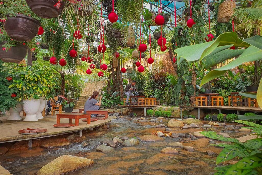 Relaxing café area with stream and plants inside Cao Nguyen Hoa, a scenic stop after the Mario Kart Dalat ride at the Dalat Flower Plateau Ecotourism Area