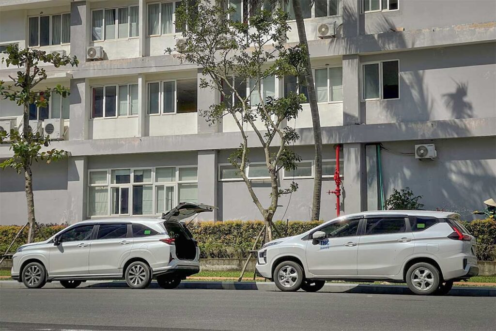 Private car rental with driver in Phu Quoc parked outside hotel building with spacious seven seat vehicles