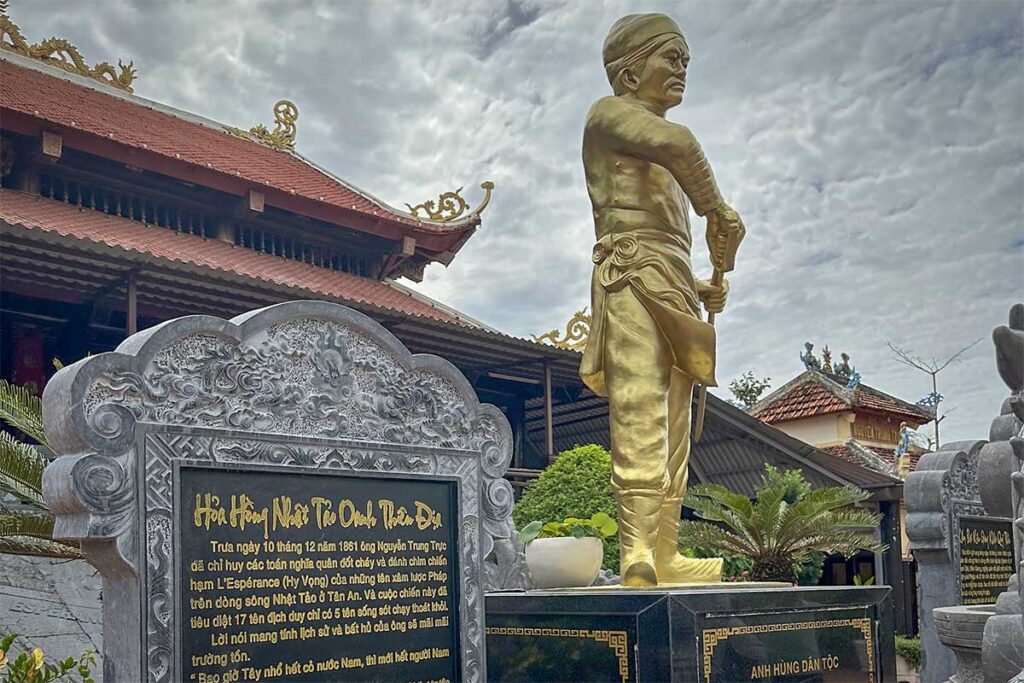 Close view of Nguyen Trung Truc statue at Nguyen Trung Truc Temple Phu Quoc with memorial stone and temple background
