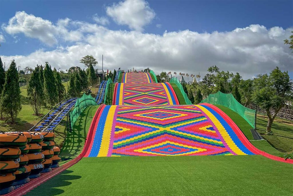 Close view of the rainbow slide at Mongo Land Dalat showing bright colored lanes and textured surface
