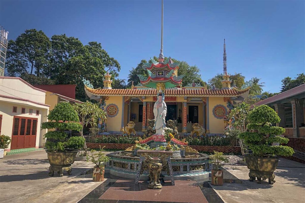Courtyard of Sung Hung Pagoda in Phu Quoc with Quan Am statue bonsai trees and main temple building