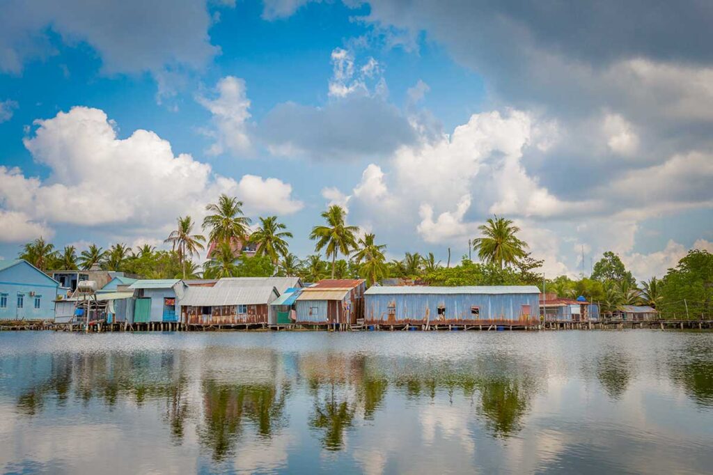 Cua Can Fishing Village Phu Quoc riverside houses on stilts with calm water and palm trees