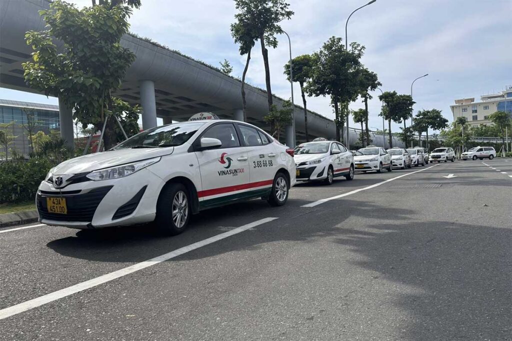 Line of Vinasun taxis outside Da Nang International Airport, ready for travelers going from Da Nang to Hoi An by metered taxi.