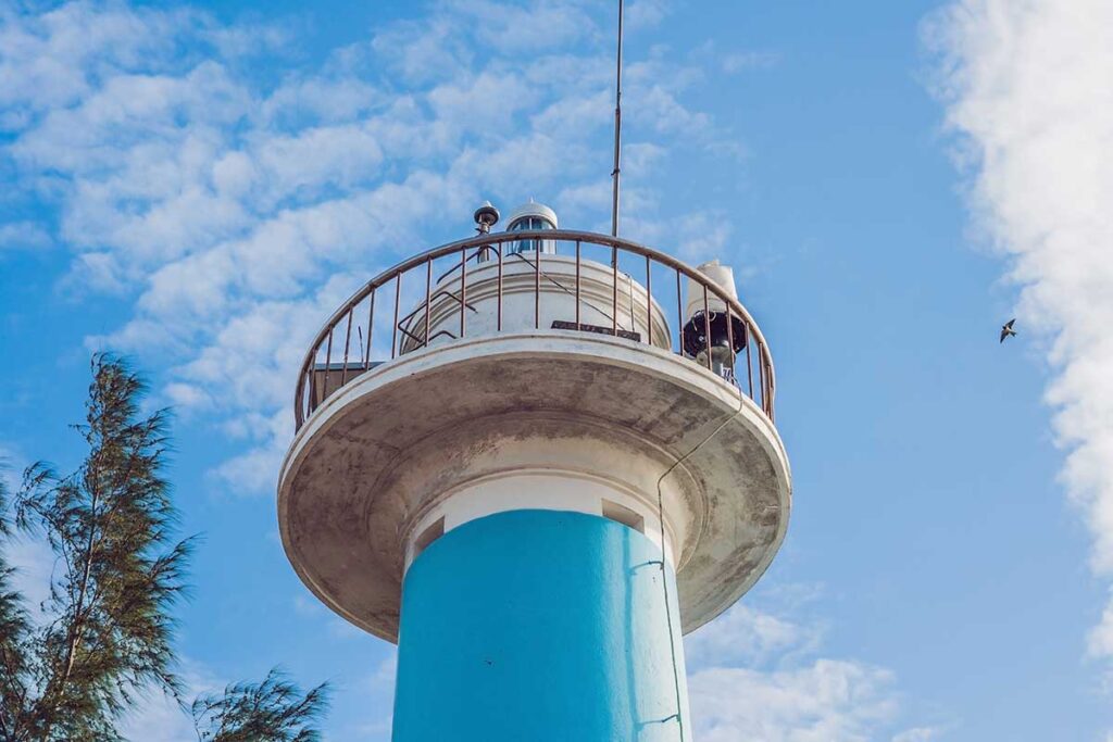 Dinh Cau Lighthouse in Duong Dong Phu Quoc with blue white tower against sky