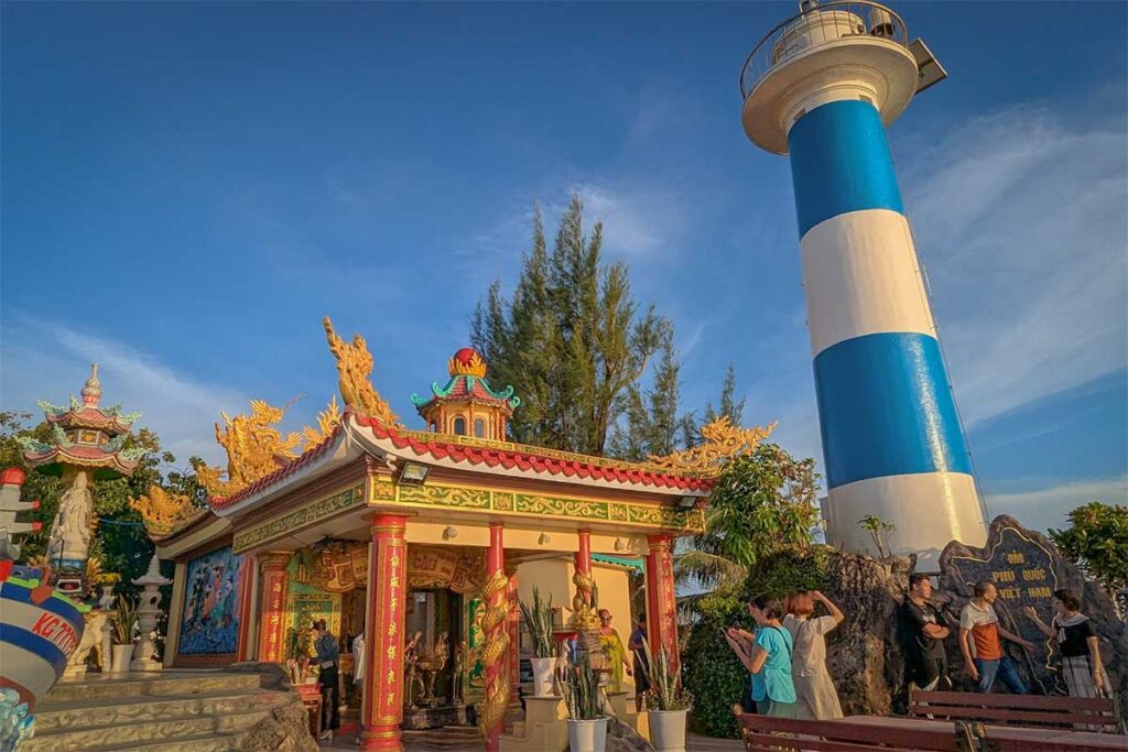 Dinh Cau Temple and lighthouse in Phu Quoc with colorful shrine and blue white tower