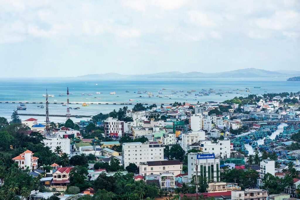 Duong Dong town Phu Quoc with harbor fishing boats coastline and city buildings viewed from above