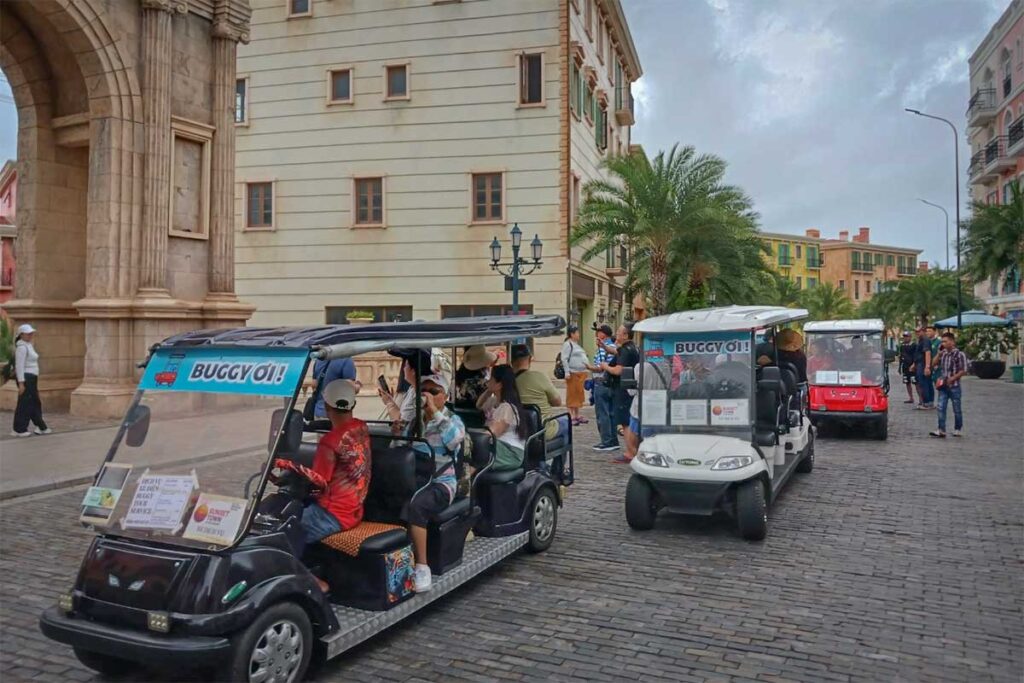 Electric buggy transport in Sunset Town Phu Quoc with tourists riding through European style streets and buildings