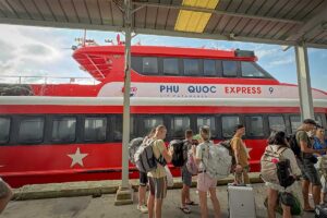 Travelers boarding Phu Quoc Express fast ferry to Phu Quoc at the port with luggage ready for departure