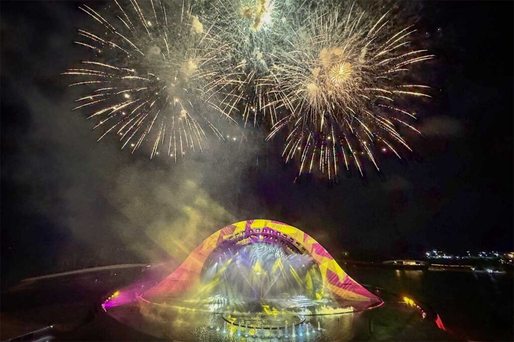 Fireworks display above Kiss of the Sea show stage in Phu Quoc with colorful lights and water effects at night