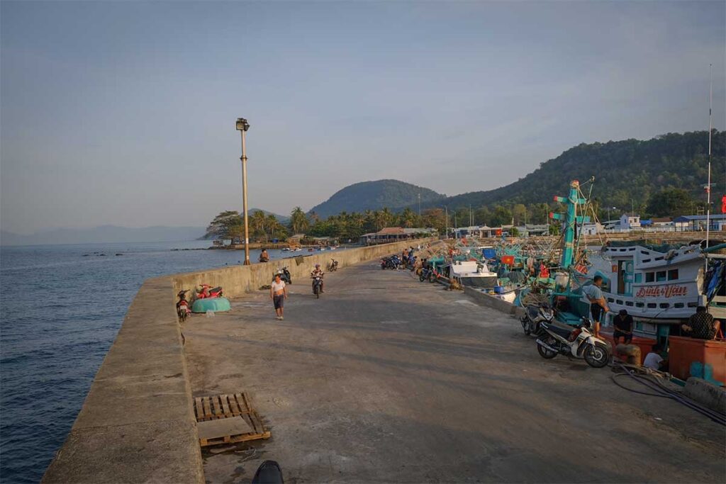 Fishing port in Ganh Dau Village Phu Quoc with boats pier and mountain backdrop