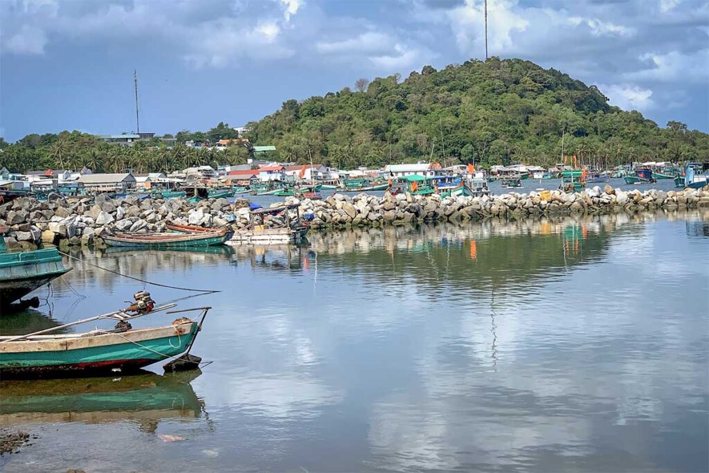 Fishing port in Ganh Dau Village Phu Quoc with boats harbor and green hill backdrop
