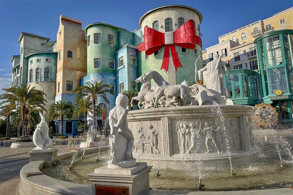 Decorative fountain in Sunset Town Phu Quoc with classical statues colorful Mediterranean buildings and large red ribbon decoration