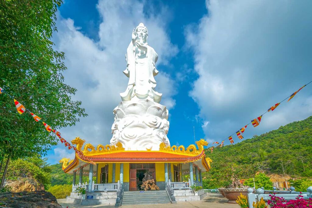 Giant white Quan Am statue at Ho Quoc Pagoda with mountain backdrop in Phu Quoc