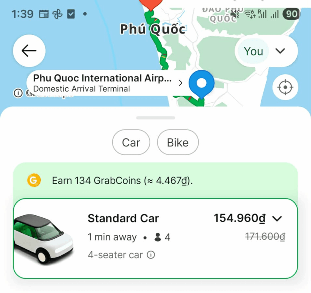 Grab app booking taxi from Phu Quoc Airport to Duong Dong with car price shown on mobile phone screen