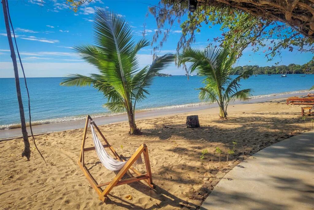 Hammock on the sandy beach at Vung Bau Beach Phu Quoc with palm trees and clear blue water