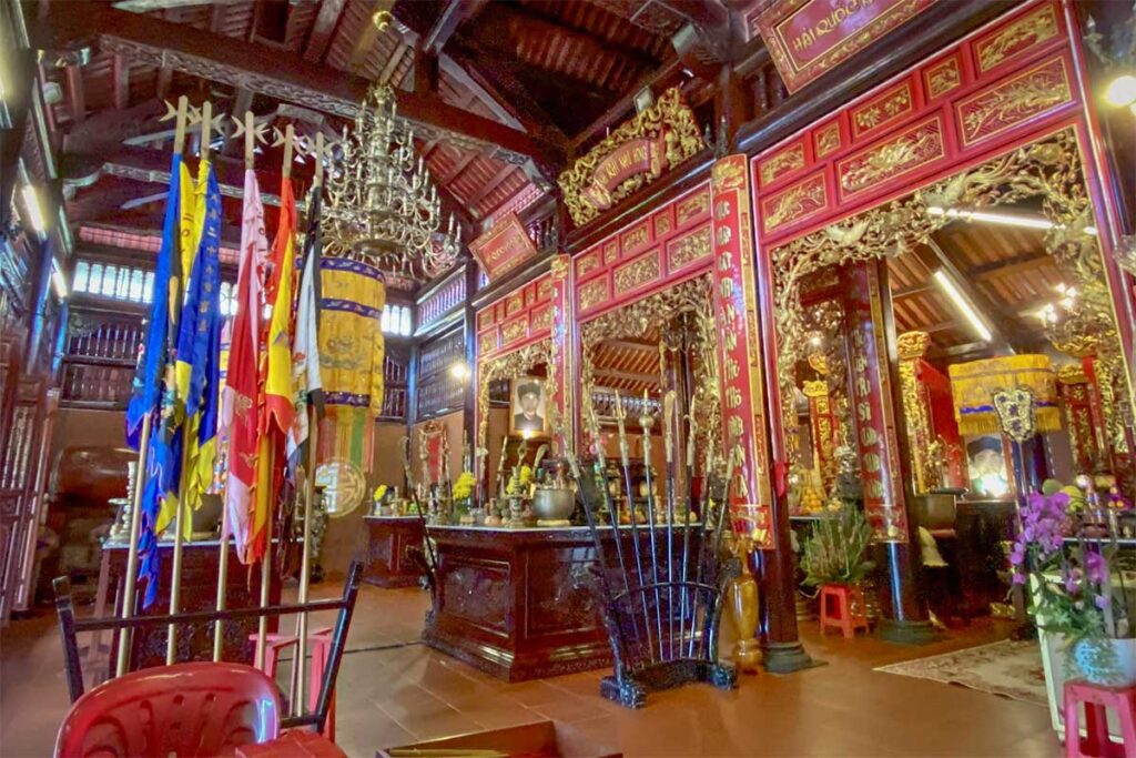 Interior of Nguyen Trung Truc Temple Phu Quoc with wooden altar flags lanterns and worship space
