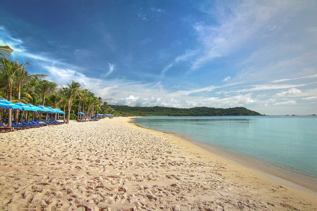 Khem Beach in south Phu Quoc with white sand calm turquoise water palm trees and sun loungers