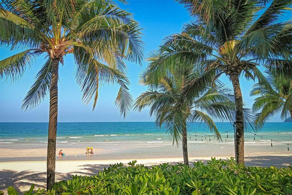 Families with kids at Bai Khem Phu Quoc beach with palm trees soft sand and shallow sea water