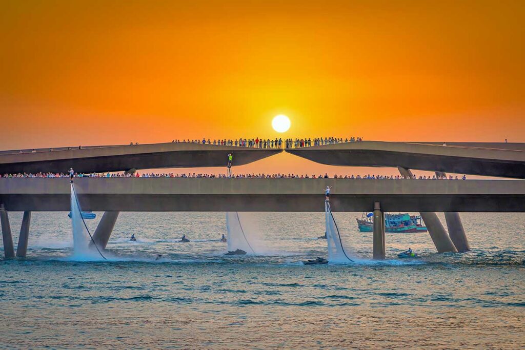 Kiss Bridge Phu Quoc at sunset with crowds watching Symphony of the Sea show and flyboard water performance below