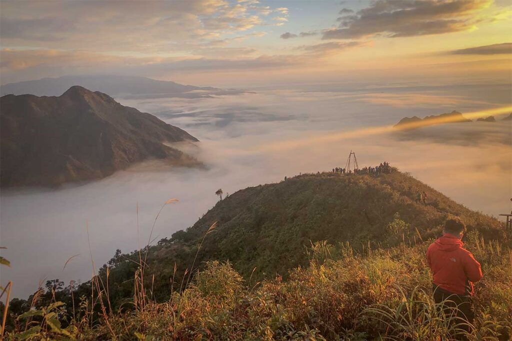 View from Ky Quan San peak with clouds covering the mountains at sunrise in northern Vietnam