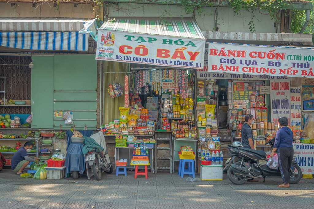 Small local shop in Vietnam with snacks and daily products displayed outside, where prices are often not clearly labeled