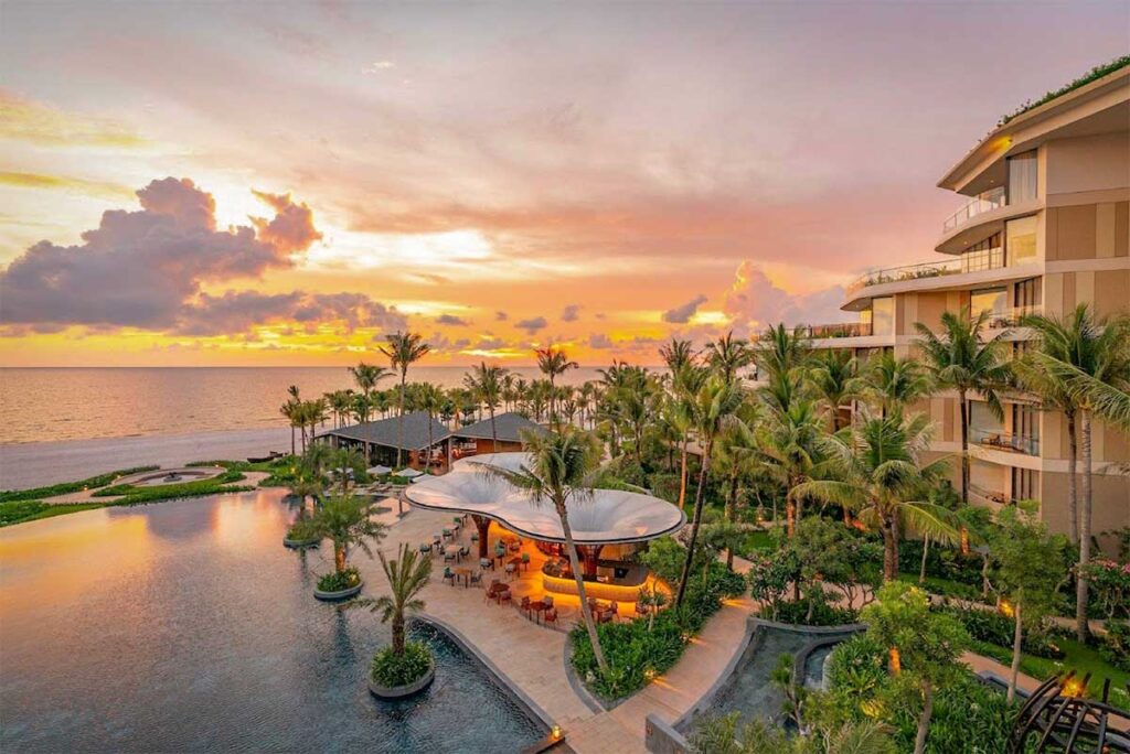 Intercontinental Phu Quoc Long Beach resort at sunset with swimming pool tropical gardens and beachfront views