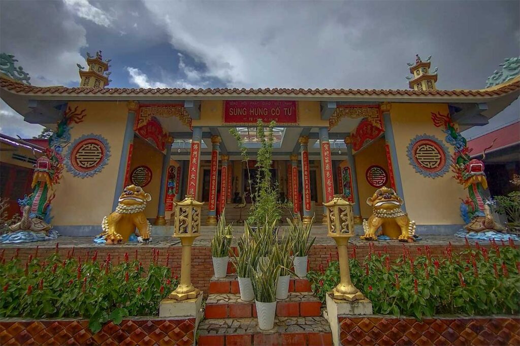 Main hall of Sung Hung Pagoda in Phu Quoc with guardian lions flowers and traditional Buddhist entrance