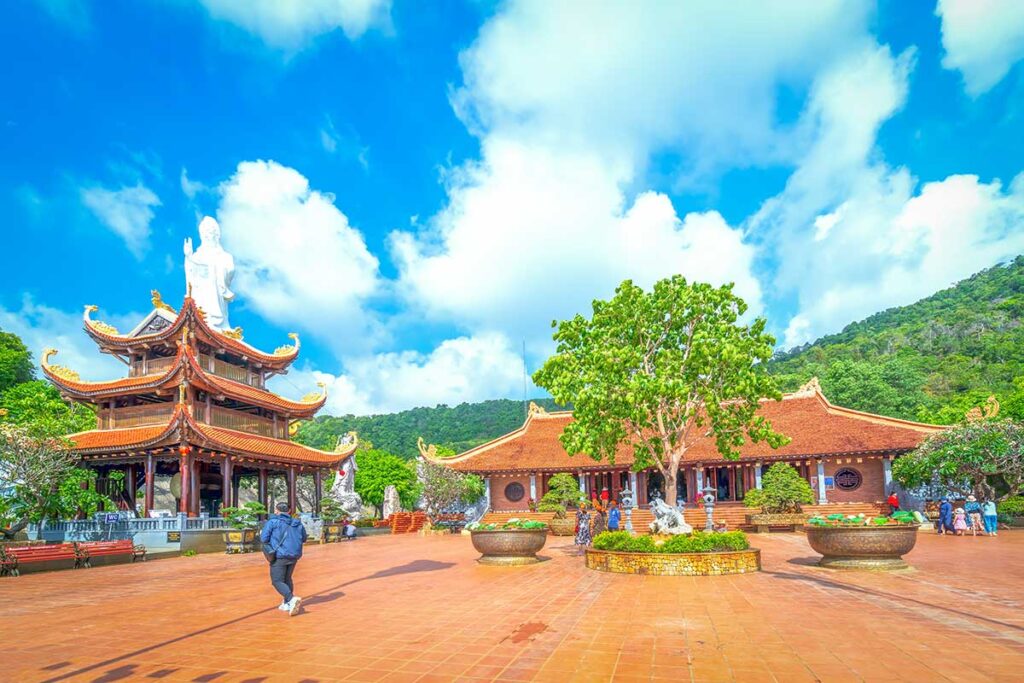 Main courtyard of Ho Quoc Pagoda with temple buildings and white Quan Am statue in Phu Quoc