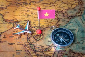 Airplane and Vietnam flag on map of Southeast Asia showing flight routes to Vietnam travel destinations