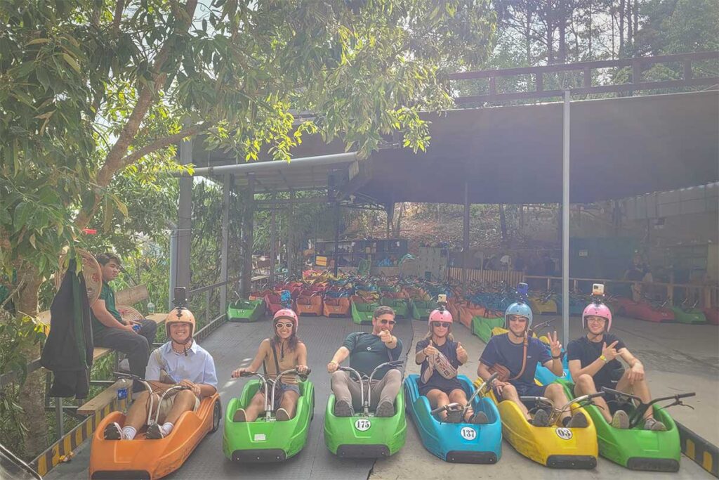 Group of foreign travelers sitting in colorful luge carts at the start of Mario Kart Dalat, ready to begin the downhill ride