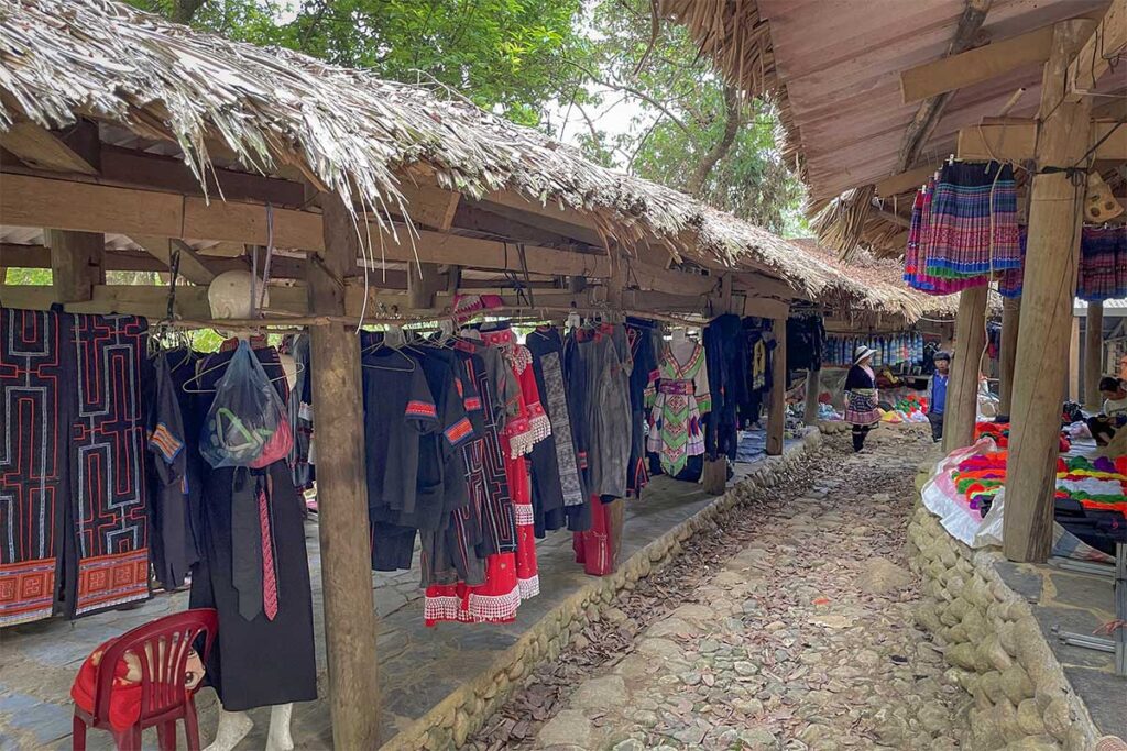 Market in Sin Suoi Ho with Hmong clothing and local products displayed along a stone pathway