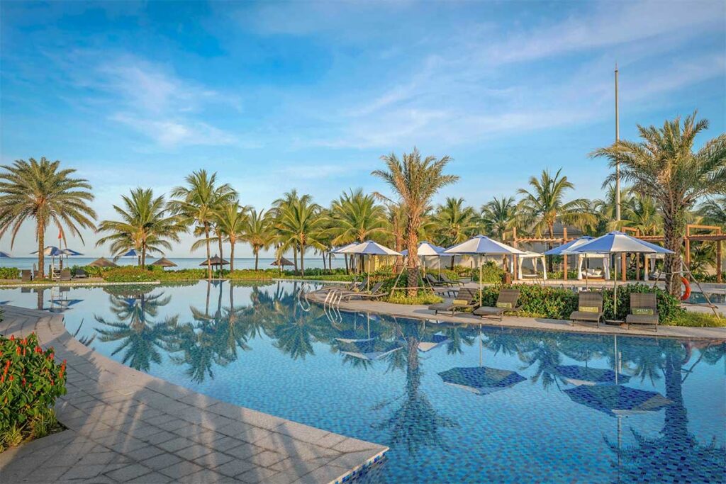 Melia Vinpearl resort pool at Bai Dai Beach Phu Quoc with palm trees and beachfront view