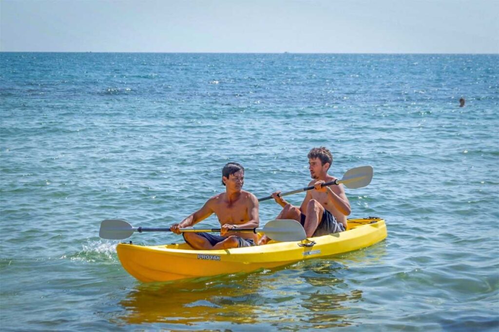 Tourists kayaking in calm sea water at Ong Lang Beach Phu Quoc during sunny day