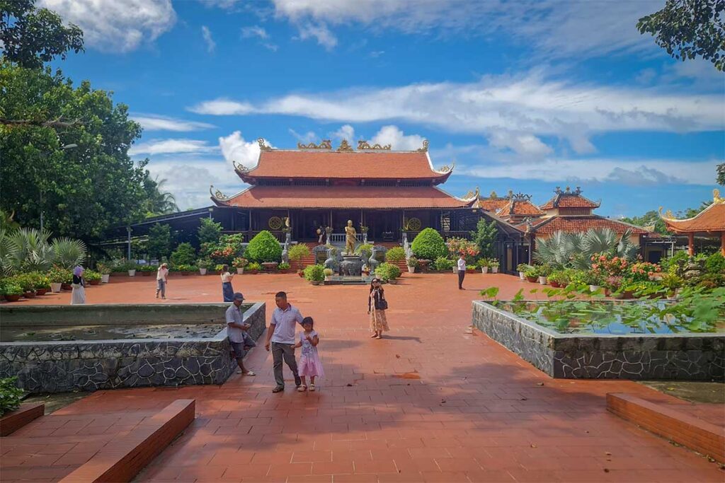 Open courtyard of Nguyen Trung Truc Temple in Phu Quoc with visitors gardens and traditional temple building