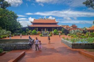 Open courtyard of Nguyen Trung Truc Temple in Phu Quoc with visitors gardens and traditional temple building