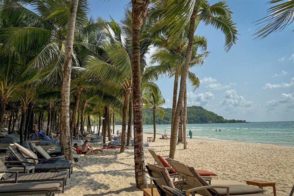Palm trees and sun loungers on Khem Beach Phu Quoc with white sand and calm sea