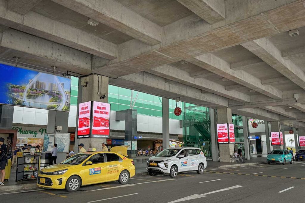 Taxis waiting outside Phu Quoc Airport arrivals area with pickup lane in front of terminal entrance