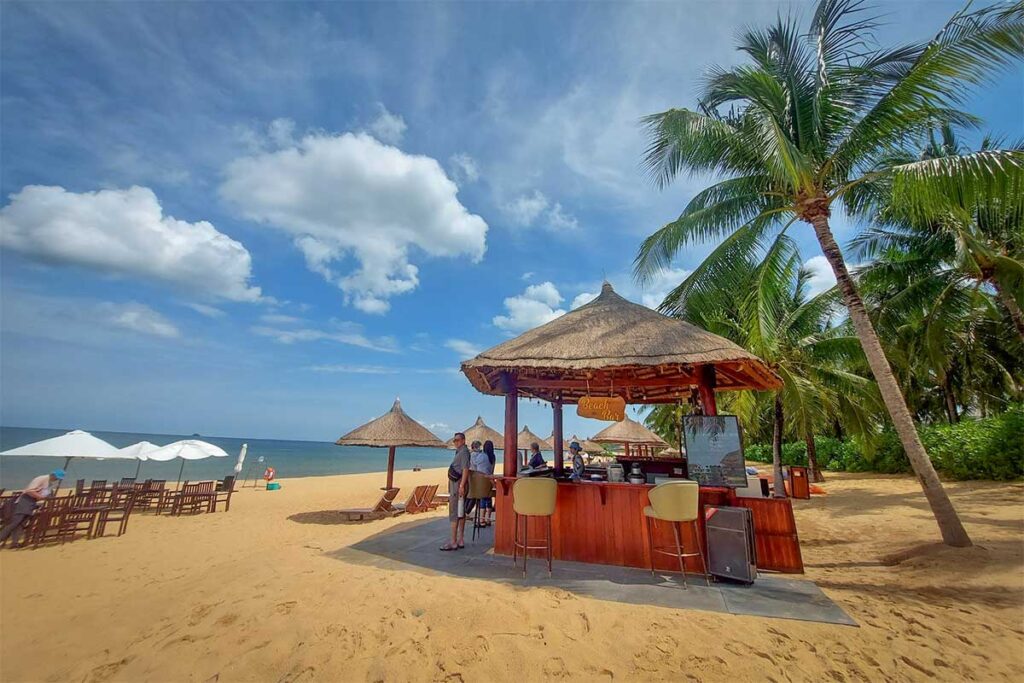 Beach bar at Bai Dai Beach Phu Quoc with palm trees sea view and seating on the sand