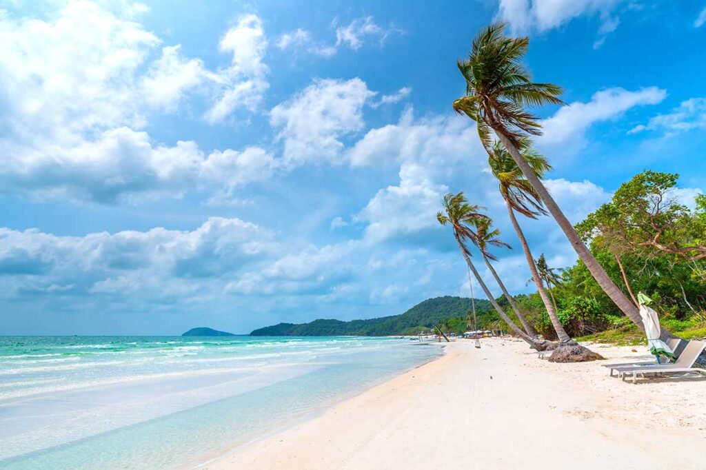 Wide white sand shoreline at Bai Sao Beach Phu Quoc with leaning palm trees and turquoise sea