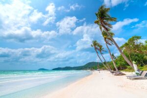 Wide white sand shoreline at Bai Sao Beach Phu Quoc with leaning palm trees and turquoise sea