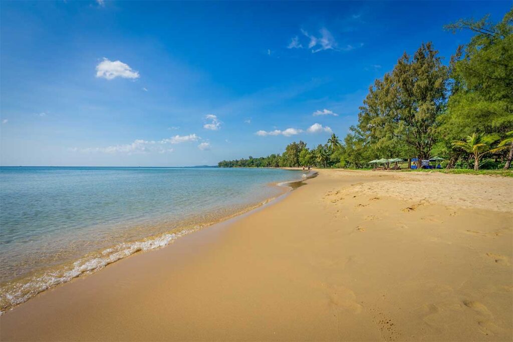 Wide sandy coast at Ong Lang Beach Phu Quoc with shallow water and tropical trees