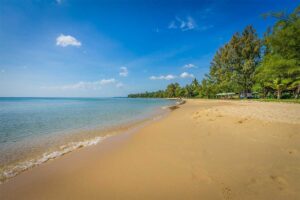 Wide sandy coast at Ong Lang Beach Phu Quoc with shallow water and tropical trees